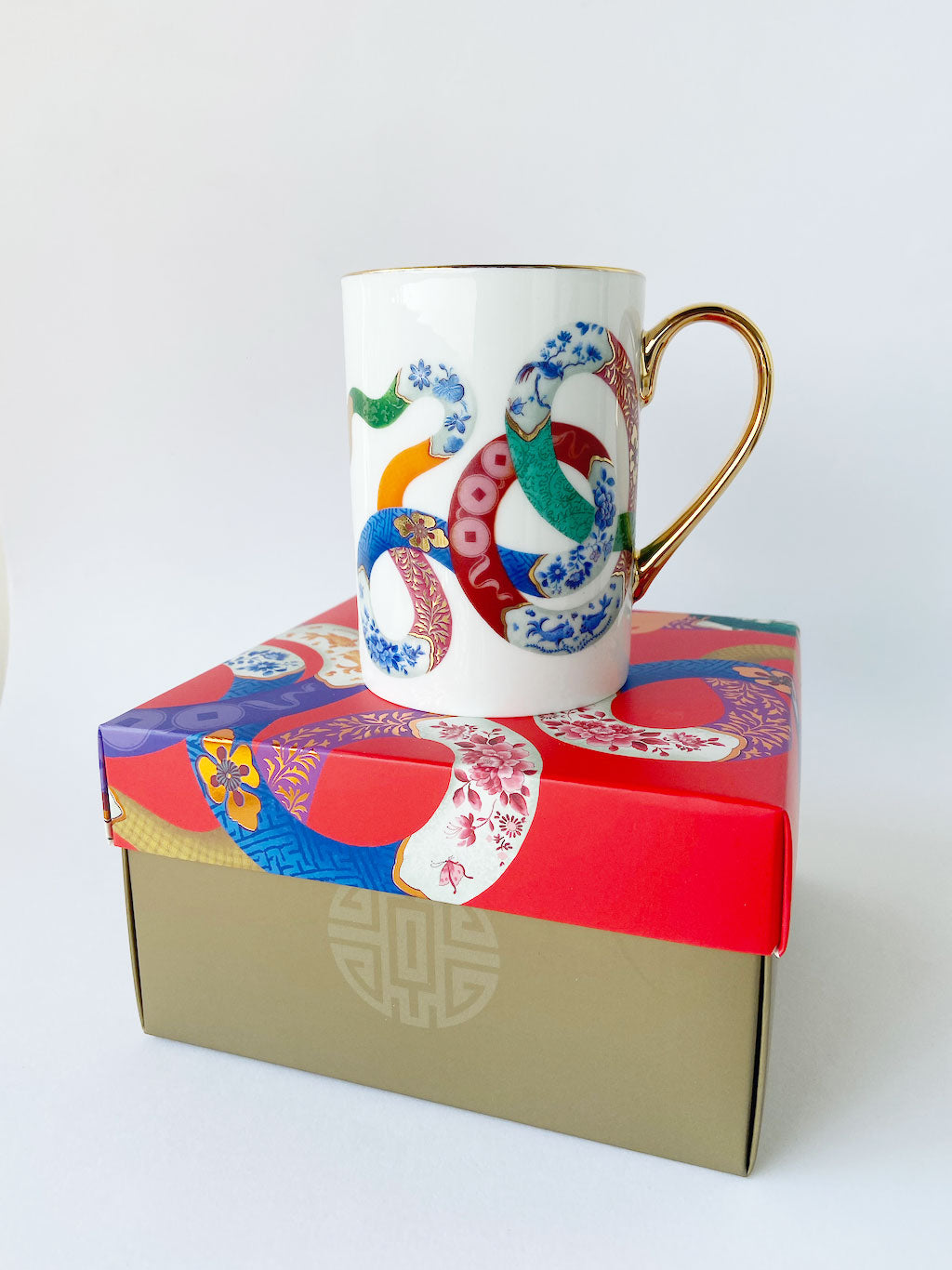 Year of the Snake fine bone china mug designed by Chris Chun, featuring a snake, carp fish, and lucky coins in intricate blue-and-white patterns with 24K gold highlights.